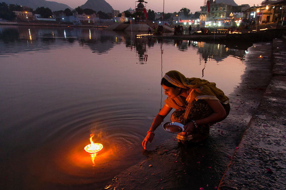 Devotees performing evening aarti on the ghats of Pushkar with lamps and holy rituals